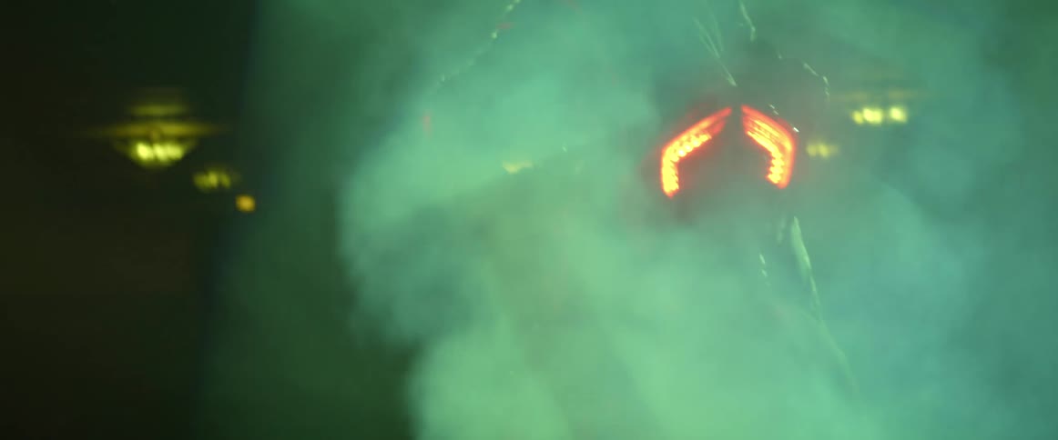 A person on a motorcycle with smoke coming out of the back of it