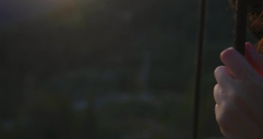 A woman is standing outdoors at dusk