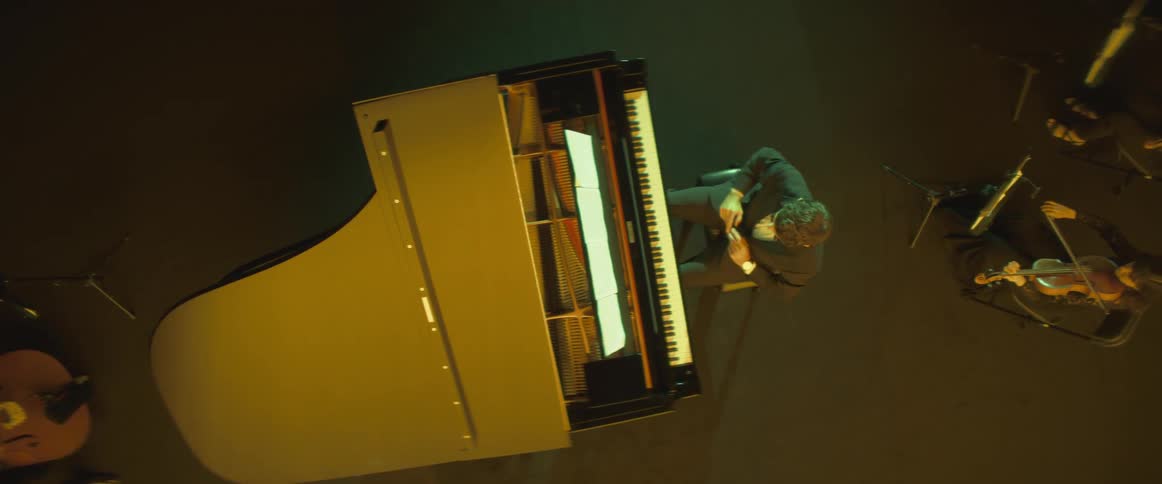 The pianist in an orchestra stretches his arms and cracks his knuckles before getting ready to play