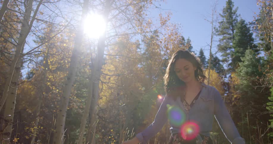 Young woman is enjoying a walk through the woods