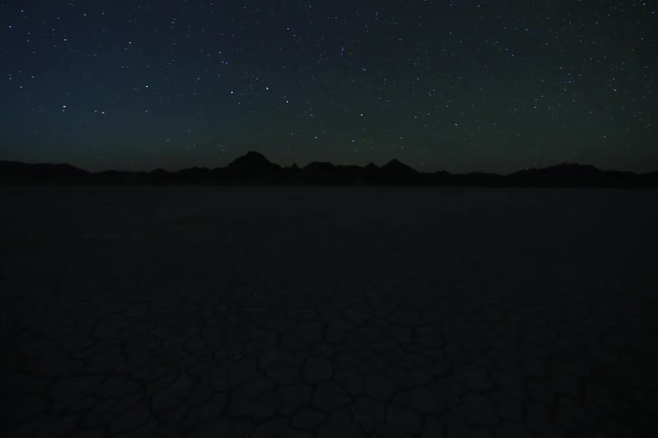 A star shoots across the night sky