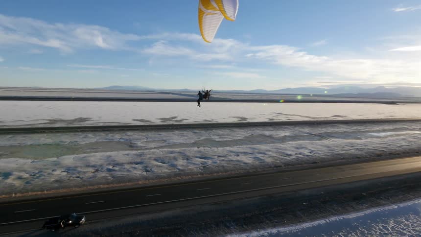 Person with parasail floating through the air