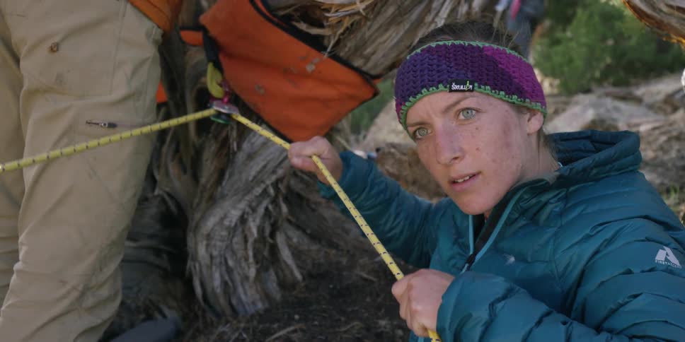 Woman releasing rope that is being pulled through a pulley