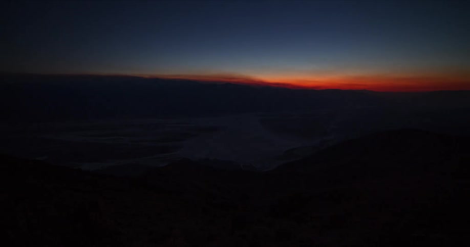 Daylight fades quickly during a time lapse over a range of mountains