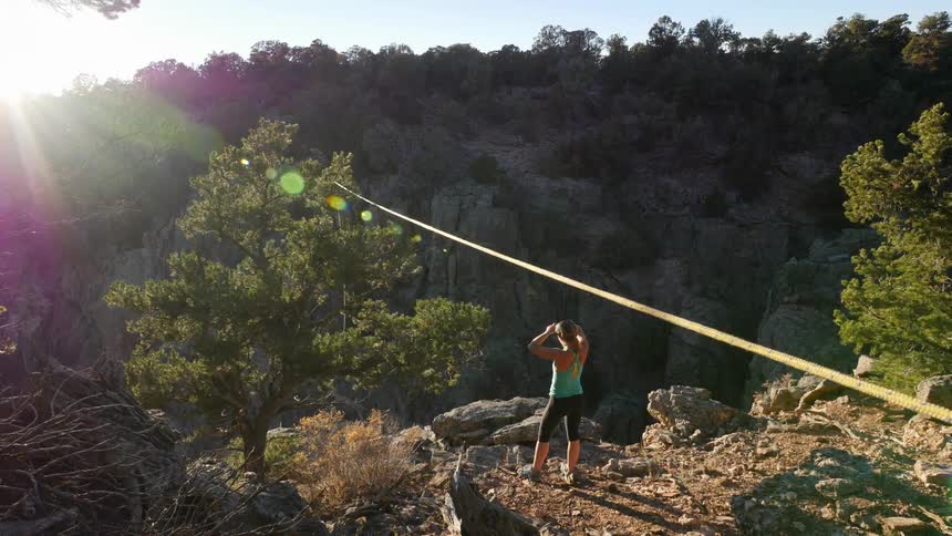 A person stretches on a rocky cliff