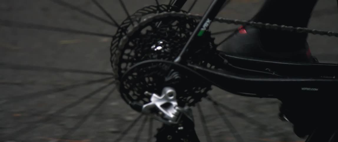 close up of a bicycle tire spinning as a person pedals on a roadway