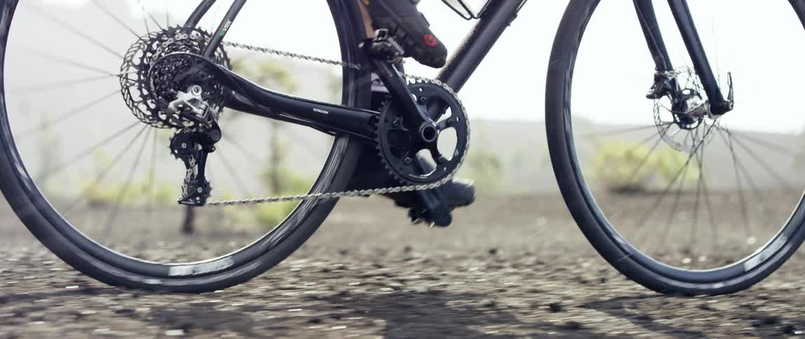 medium close up of a gravel bike riding over black gravel