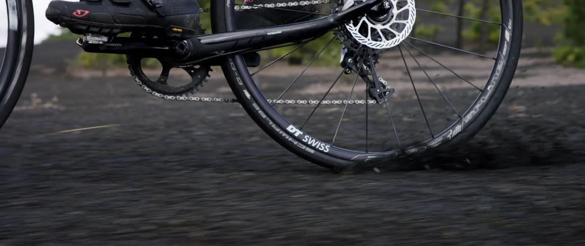 close up of a bike tire breaking and locking up on black gravel