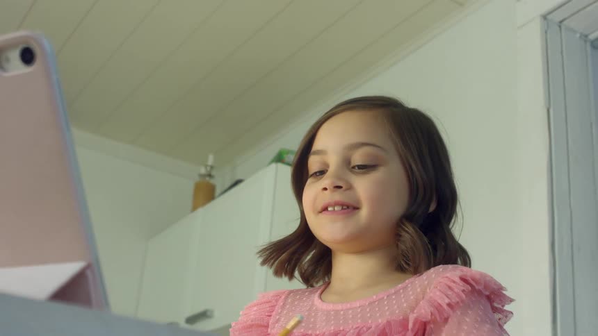 Girl doing homework from home on a video call in a tablet