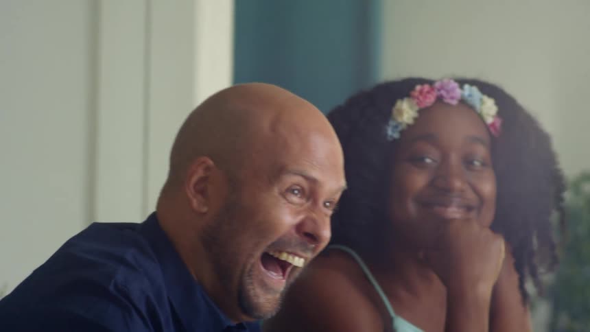 A man and a woman sitting at a table smiling and laughing