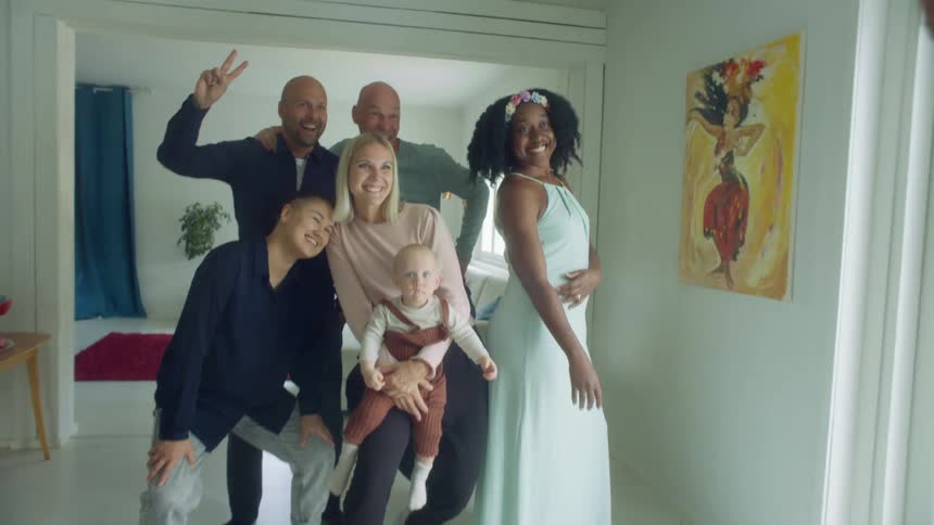 A group of people pose for a photo in a home
