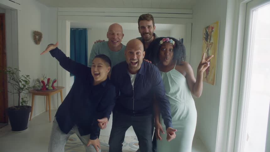Group of friends gather in the living room posing for a picture looking at the camera