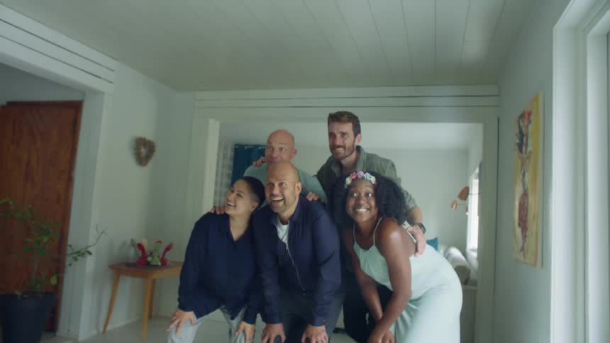 Friends posing for a blonde female taking a picture on a cell phone