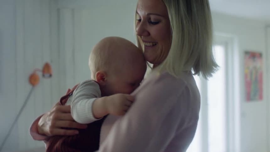 A mother rocks her son around the room