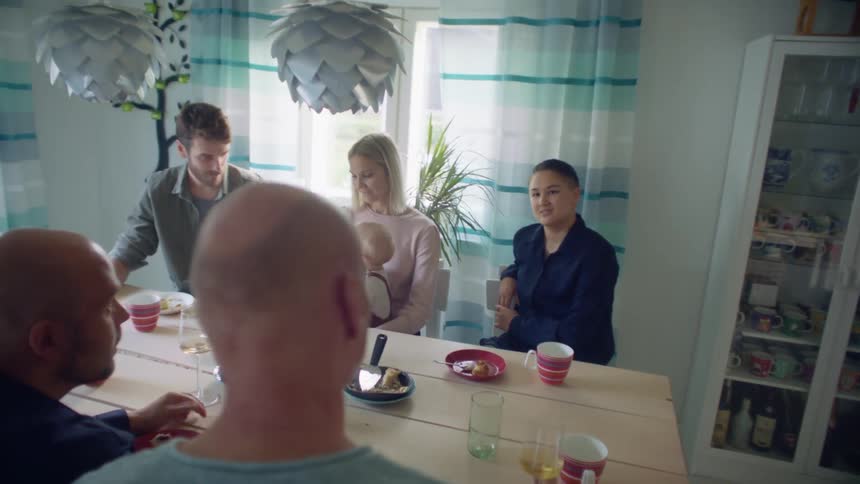 Family and friends sitting at the dinner table having lunch at home