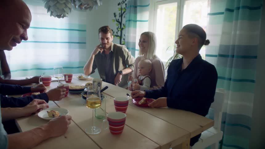 Group of friends and family eating lunch in the dinner table at home