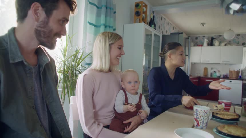 Family and friends having lunch in a table on the kitchen at home