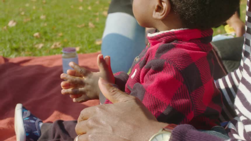 Adorable black toddler rubbing sanitizer on his hands