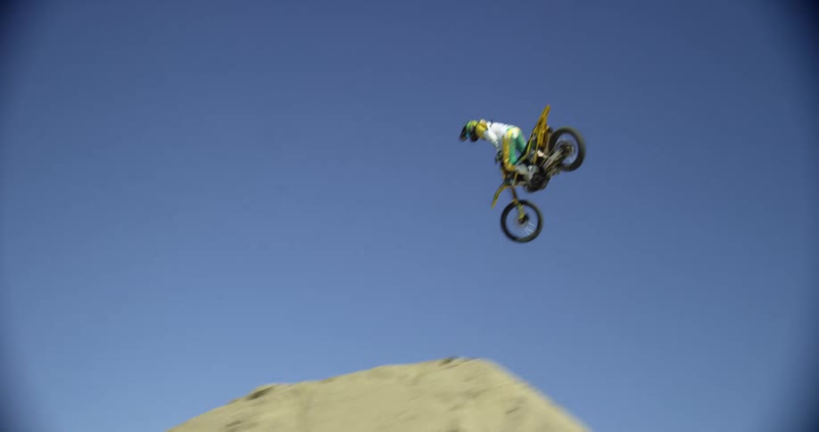 A person on a motocross bike performs a large jump