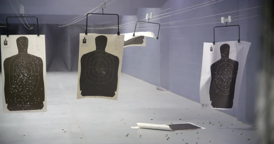 Bullets hitting paper targets at a shooting range