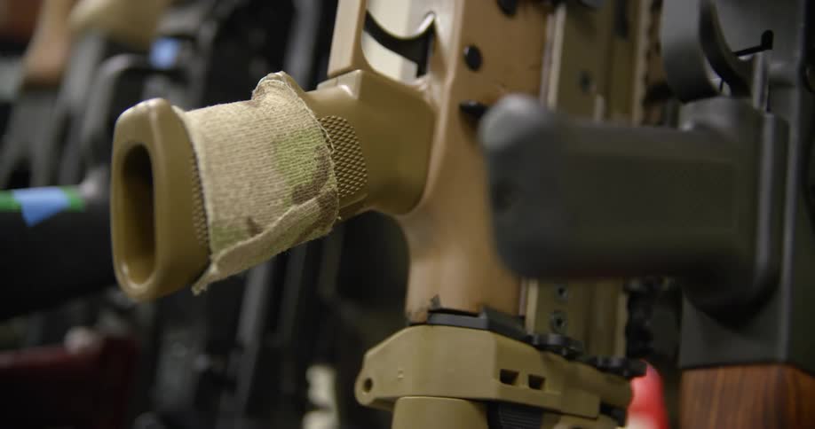 Rifles sit vertically and side by side in a gun store