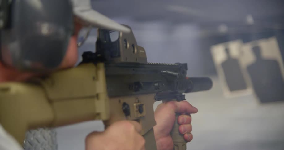 Man fires at practice targets with an automatic rifle on a shooting range