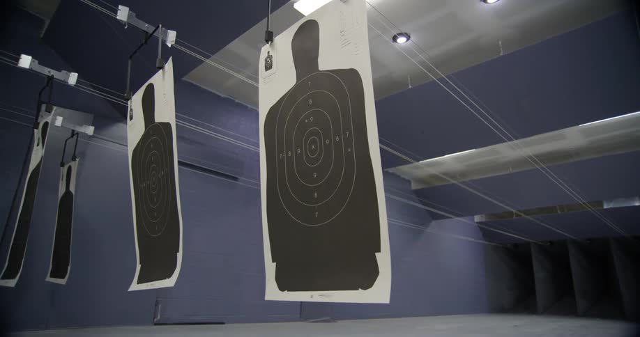 Paper shooting targets sway while hanging in an indoor shooting range
