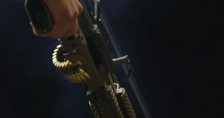 Shell casings go flying as a man fires multiple bullets from an assault rifle