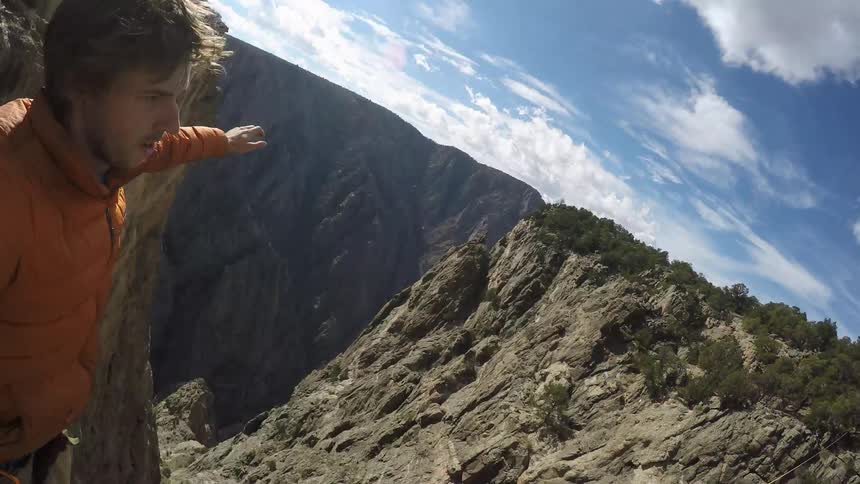 A man slowly stands on a tightrope
