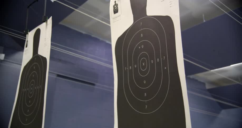 Paper targets hanging from a ceiling at a shooting range