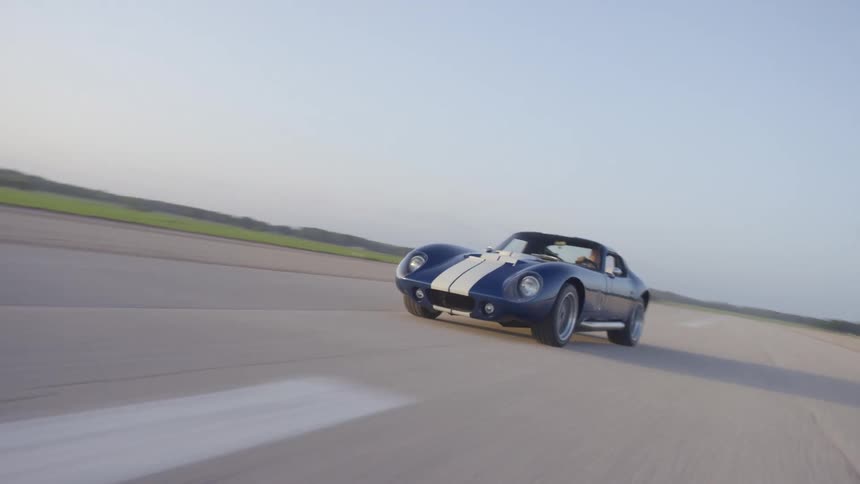 A car is driving on an empty road in spring