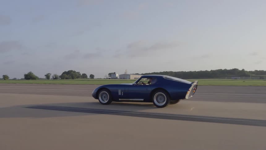 Daytona shelby coupe race car driving down a runway at full speed