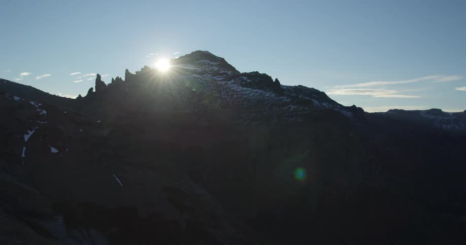 Mountain view with the sun rising in a blue sky