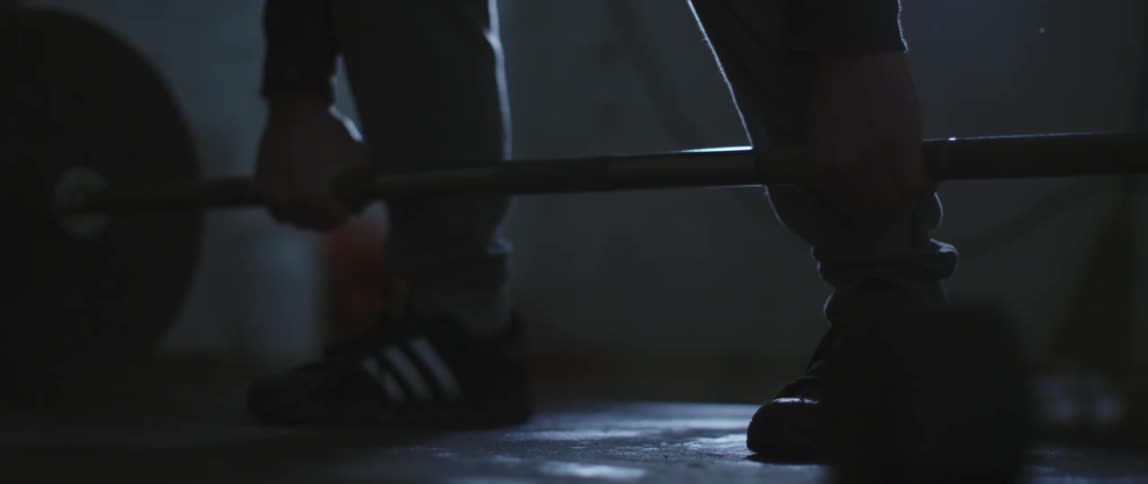 A person is deadlifting with a barbell