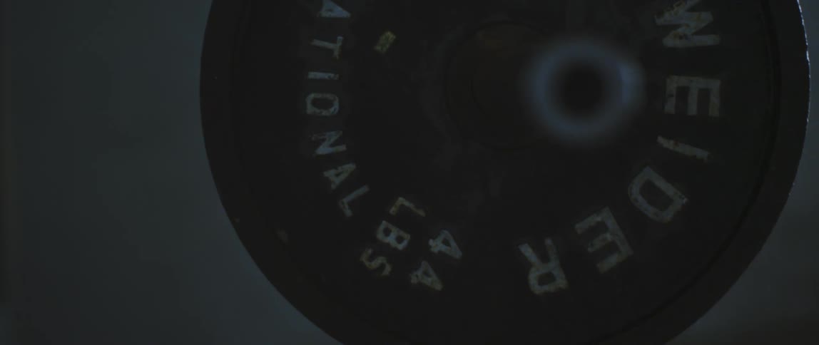 Man lifts up a barbell with weights in the gym