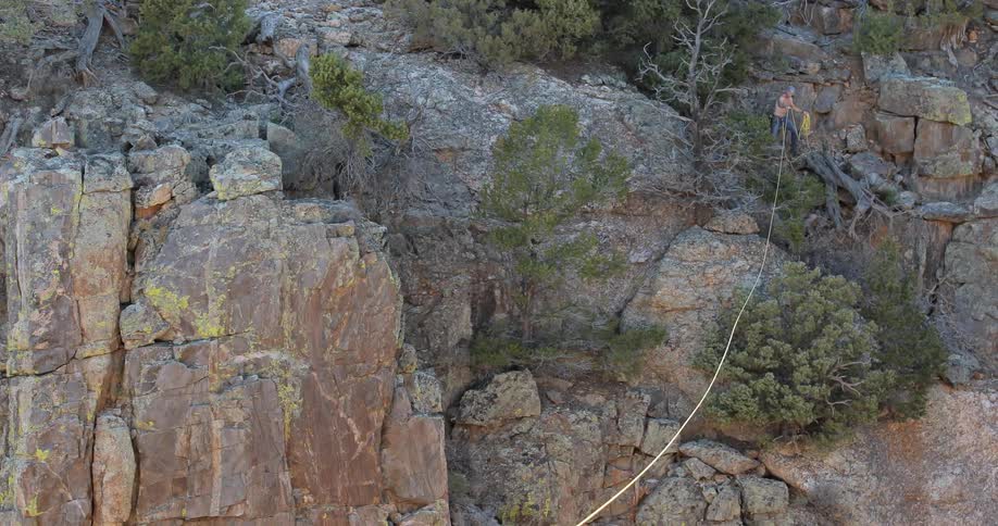 Person is setting up a tight rope across a canyon