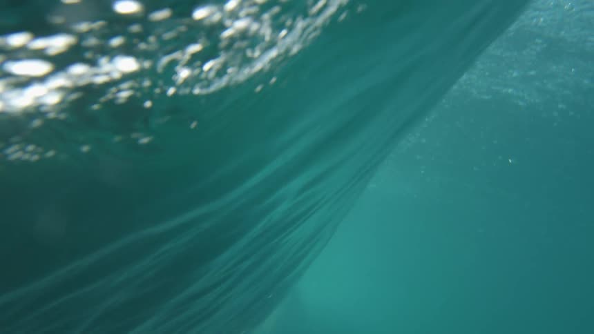 A wave cresting and crashing with shots on the surface and underwater
