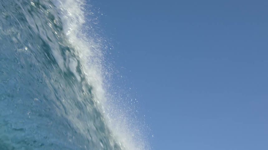 A tall wave crashes down in the ocean
