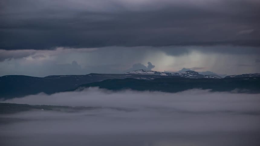 Clouds and fog rising to cover the mountain landscape in Norway