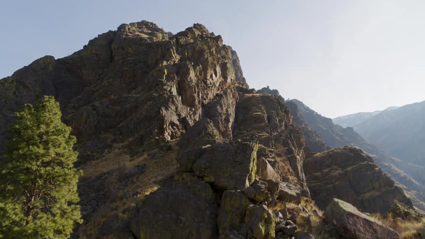 Rising along the sun kissed summit of a rugged mountaintop