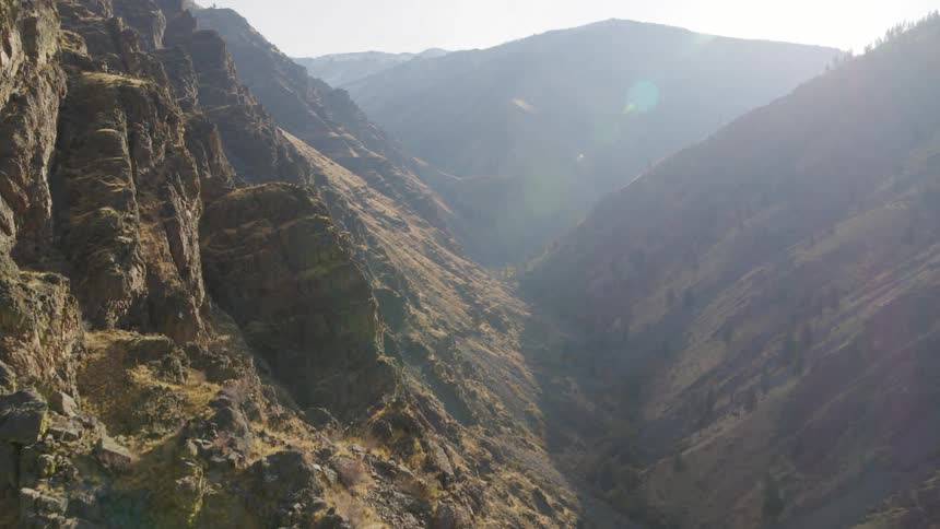 Tilt down reveal of an extremely deep valley between two steep mountainsides
