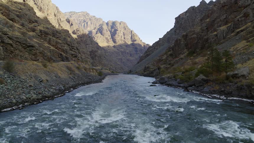 Flying above whitewater rapids along a mountain river gorge