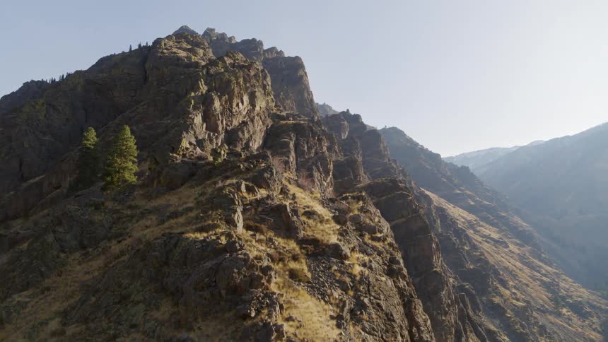 Skimming above a rocky ridgeline along a tall mountain peak