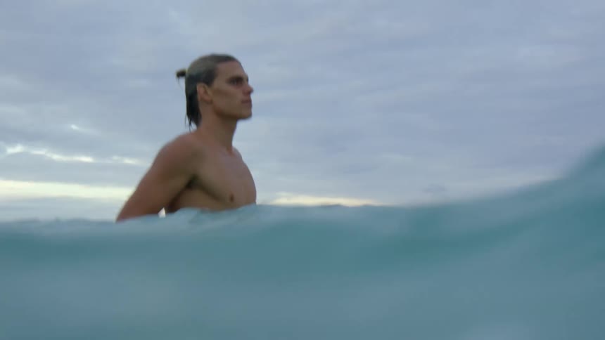 A man paddling on his surf board in the ocean