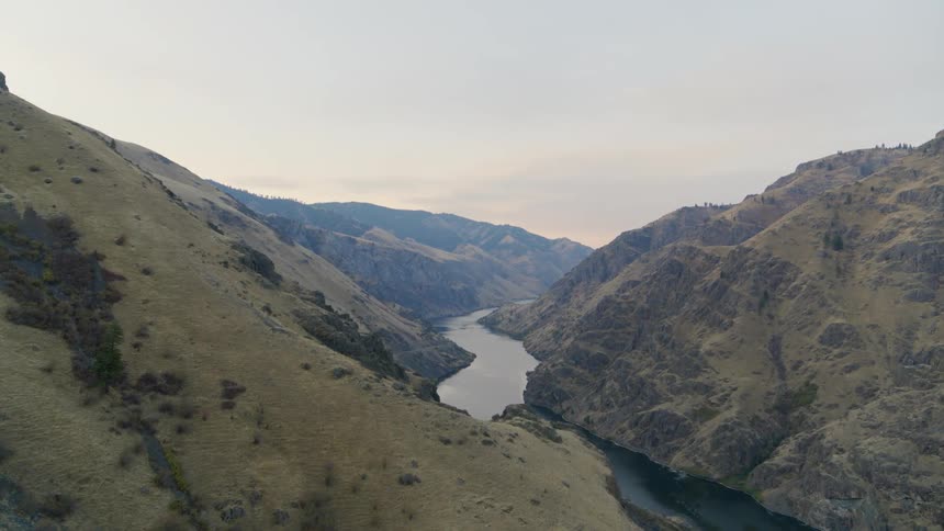 Reveal of a narrow river flowing within a deep mountain gorge