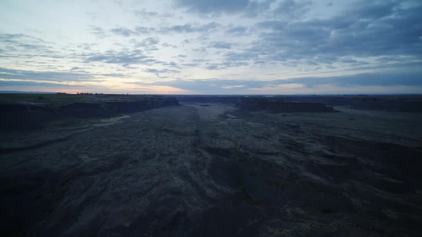 Tilt up reveal of the early morning sky above a surreal terrain of carved rock canyons