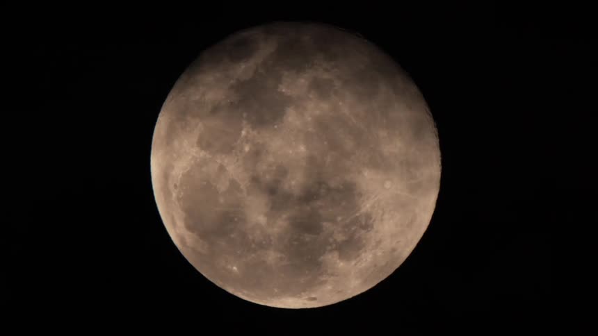 Full moon on dark night with clouds passing over