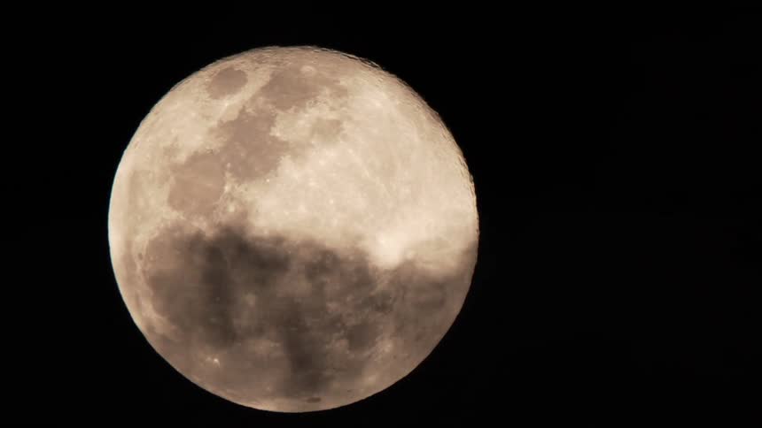Clouds drift past the moon