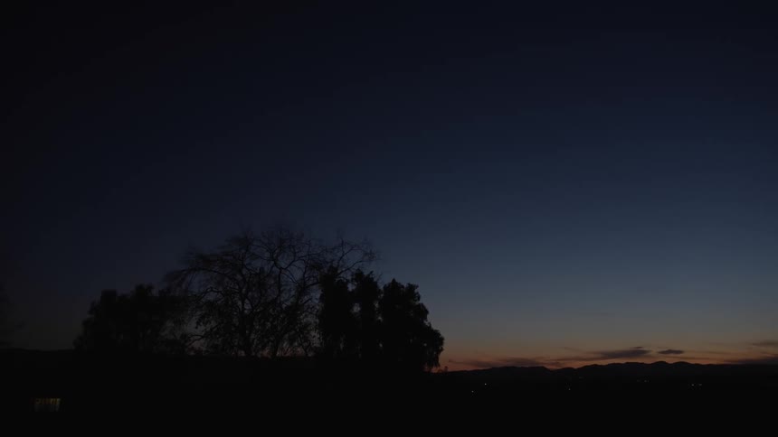 A landscape of a tree and red sky with clouds