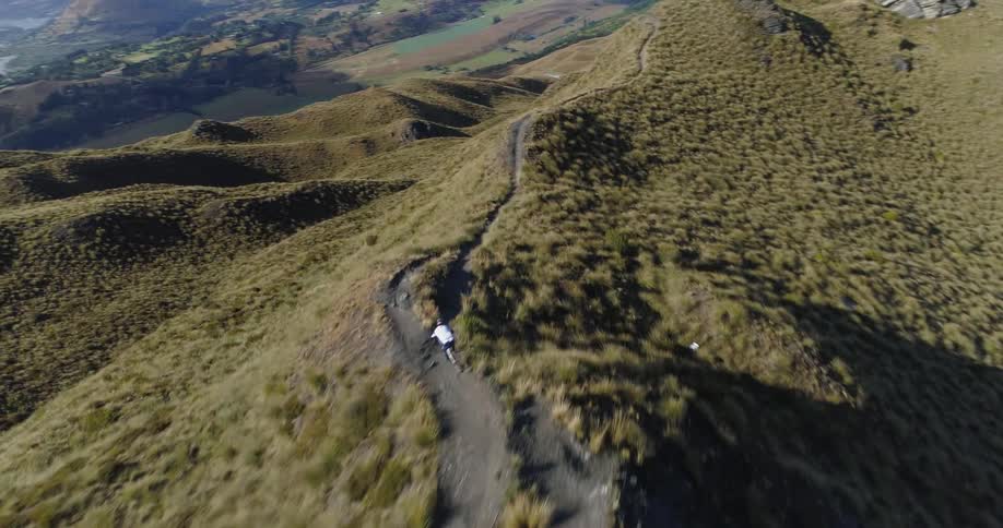 Cyclist rides bicycle on mountain ridge bike trail